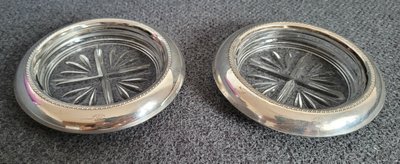 Two vintage crystal coasters with a sterling silver rim.