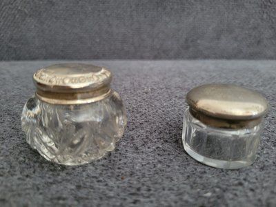 Two small antique crystal jars with silver lids.&nbsp;