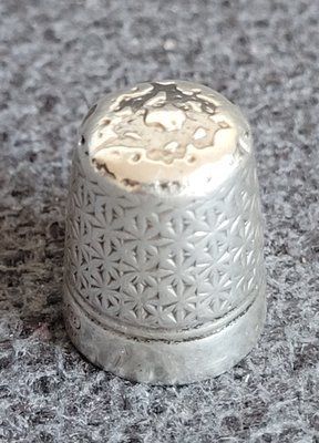 An antique silver thimble by Charles Horner.