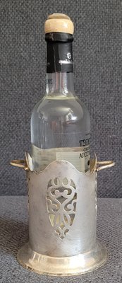 Antique silver-plated stand for a small bottle.