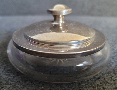 An antique crystal powder jar with a lid made of pure silver