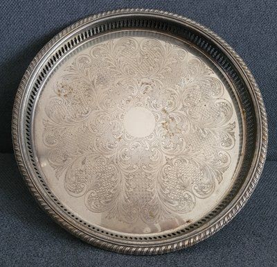 A large round silver-plated tray with beautiful engraving.