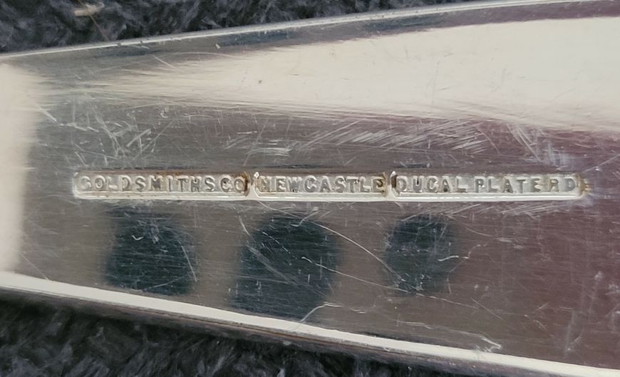 A set Goldsmiths & Silversmiths Co Ltd of antique silver-plated spoons with a large serving spoon