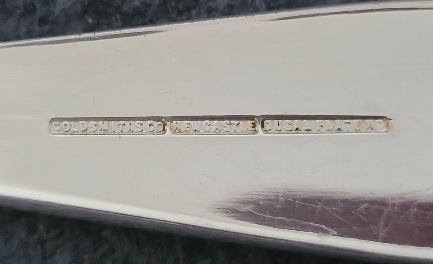 A set Goldsmiths & Silversmiths Co Ltd of antique silver-plated spoons with a large serving spoon