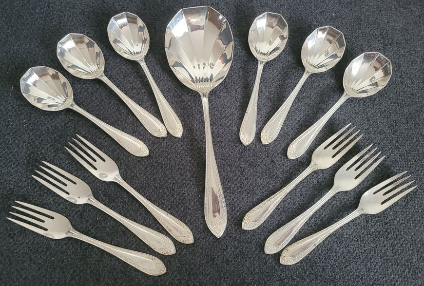 A set Goldsmiths & Silversmiths Co Ltd of antique silver-plated spoons with a large serving spoon