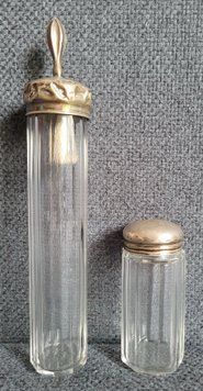 Two antique glass vials with silver lids.