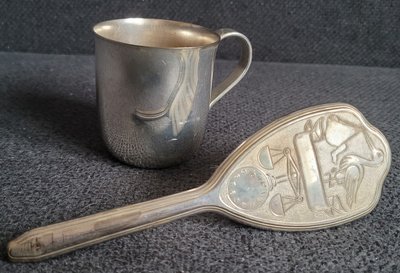 Vintage children's silver hair brush and silver-plated mug.
