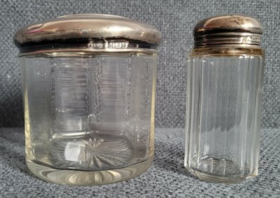 Two vintage jars with silver lids.