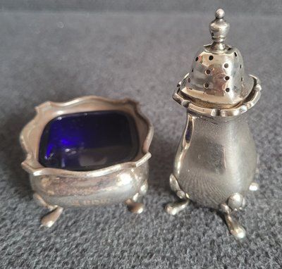 Antique silver pepper shaker and salt bowl.